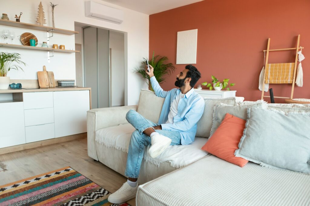 Contented arab man relaxing under the air conditioner at home